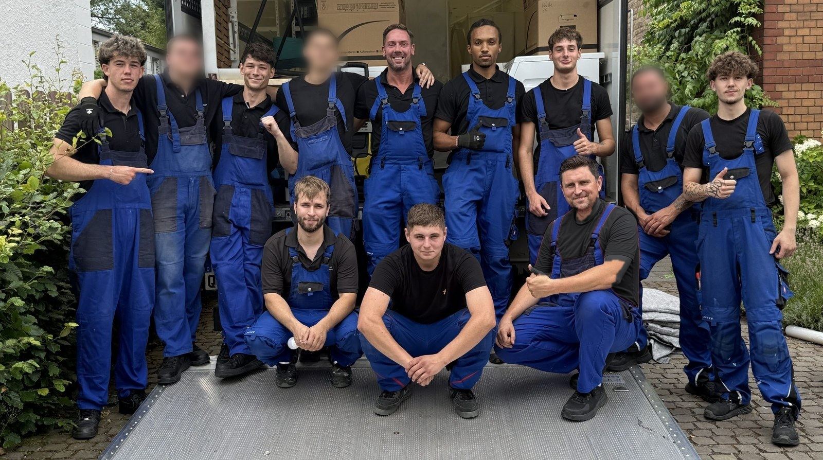 Das Team der Umzugsunion steht vor der geöffneten Ladebordwand des Umzugswagens