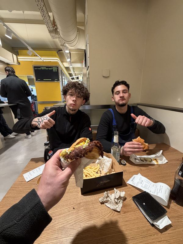 Zwei Kollegen sitzen nach dem Vormittag beim Essen zusammen an einem Tisch