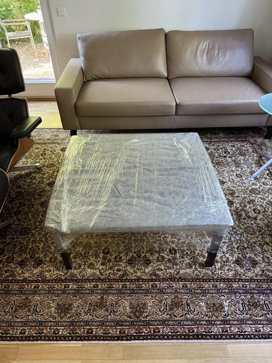 Verpackung beim Umzug in Bergisch Gladbach, ein Sofa und ein Couchtisch stehen im Wohnzimmer und sind vor dem Transport komplett in Schutzfolie eingewickelt.