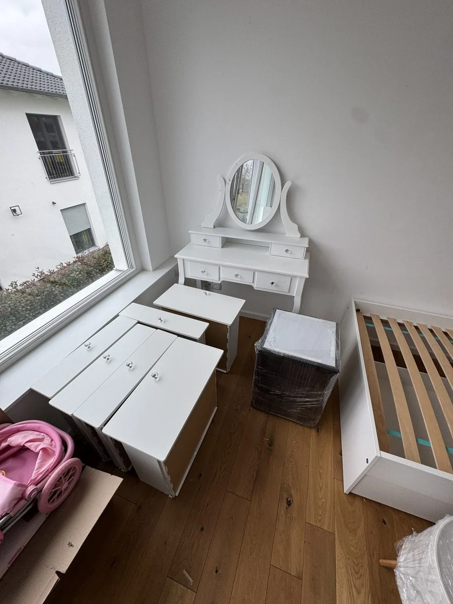 Ein von oben fotografiertes Zimmer mit weißen Möbeln, die nach dem Aufbau fertig an ihrem Platz stehen.
